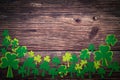 St Patricks day, golden coins, festive hat and green Shamrocks on wooden Royalty Free Stock Photo