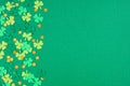 St Patricks Day green background with shamrock and gold coin confetti side border