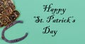 St Patricks day Irish good luck items with golden coins and horseshoe on a green paper background plus text Royalty Free Stock Photo