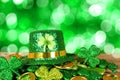St Patricks Day leprechaun hat on a pile of gold coins and shamrocks with twinkling green background