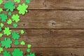 St Patricks Day side border of shamrocks, above view over an old wood background with copy space Royalty Free Stock Photo