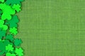 St Patricks Day side border of shamrocks over green linen Royalty Free Stock Photo