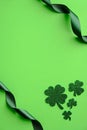 St Patricks day vertical banner design. Top view shamrock four leaf clover and ribbons on green background. Saint Patrick`s day