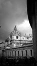 St. Peter`s Square with Bernini`s colonnade on the sides, with Latin inscriptions on the facade and large antique clock on a clou