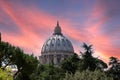 The st peters basilica catholic church dome in rome italy during sunset and pink skies.