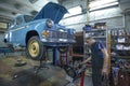 Car mechanic in the garage repairs the engine of the Soviet retro car Moskvich-403