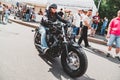 A Biker rides a black motorcycle among people