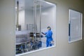 Pharmaceutical factory, pure insulated plant for the production of drugs in ampoules. Lab technician controls the manufacturing