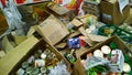 Pile of dirty cardboard boxes with canned food. Clutter, trash and scattered goods. Mess. Old Produce. Supermarket waste. Grocery