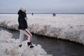 Tourists stroll along the coast of the Gulf of Finland. Sunny, fine day after a hurricane and an ice storm