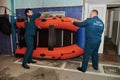 Two firefighters prepare a special inflatable boat for an emergency trip to the site