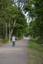 A man on a bicycle rides along an alley in the Central Park of Culture and Leisure Dubki city of Sestroretsk, St. Petersburg