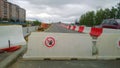 Plastic red and white heavy duty water filled road traffic barrier. Construction of freeway near multi-story residential buildings
