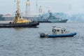 ST PETERSBURG, RUSSIA - JULY 28, 2017: River tug and patrol boat on the background of a warship