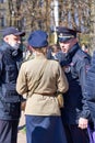 Police detain a woman in military uniform on the street of St. Petersburg