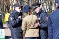 Police detain a woman in military uniform on the street of St. Petersburg