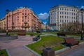 ST. PETERSBURG, RUSSIA, 01 MAY 2018: View od wooden public chairs in a park with huge buildings behind located in