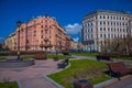 ST. PETERSBURG, RUSSIA, 01 MAY 2018: View od wooden public chairs in a park with huge buildings behind located in