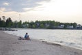 A young man sits next to a bicycle on the sandy shore Royalty Free Stock Photo