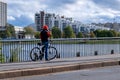 Cyclist talking on the phone while standing on a bridge
