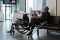 St. Petersburg, Russia - October 8, 2018: An elderly bald disabled person in the departure lounge before boarding a plane looks at