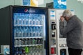 elderly man at the airport chooses a soft drink in a vending machine. Commercial