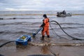 Employees of the environmental service clean up after low tide on the coast Gulf of Finland remove garbage, oil spills, harmful