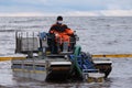 Employees of the environmental service clean up after low tide on the coast Gulf of Finland remove garbage, oil spills, harmful