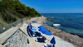 View on small sand beach mith blue umbrellas and sunbeds at mediterranean sea in summer Royalty Free Stock Photo