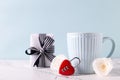 Blue cup with hot drink, white tender roses flowers, red lock in form of heart and box with gift