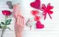 St. Valentine`s Day, Love concept. Young couple taking hands, over holiday decorated wooden background. Top view