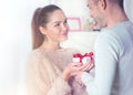 St. Valentine`s Day. Young man giving a gift to his girlfriend Royalty Free Stock Photo