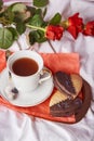 St Valentines breakfast in bed among red traditional roses - vegan heart shaped cookies and coffee cup on the sheets Royalty Free Stock Photo