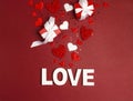 St. Valentines Day background word love, gifts and decorative hearts on red. Royalty Free Stock Photo