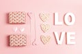 St. Valentines Day composition with word love, gifts and decorative hearts on pink background Royalty Free Stock Photo