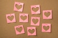 St valentines day concept. Photo of pastel pink notepaper with cut hearts attached to the wooden board with pins Royalty Free Stock Photo