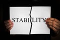 stability inscription torn in half on a white sheet of paper in the hands Royalty Free Stock Photo