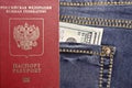 A stack of American hundred dollar bills in the back pocket of blue jeans and an international passport of the Russian Federation Royalty Free Stock Photo