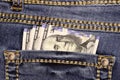 A stack of American hundred dollar bills in the back pocket of blue jeans. Money in your pocket Royalty Free Stock Photo