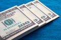 A stack of American hundred-dollar bills lies on a blue background in close-up Royalty Free Stock Photo