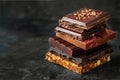 Stack of assorted chocolate bars with nuts and fruit toppings