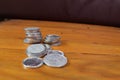 A stack of assorted coins on the wooden table