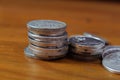 A stack of assorted coins on the wooden table