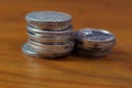 A stack of assorted coins on the wooden table