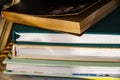 Stack of assorted hardback and paperback books or journals - some with bookmarks - closeup detail with selective focus