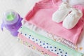 Stack of baby clothing with a feeding bottle