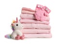 Stack of baby girl`s clothes, socks and toy unicorn on white Royalty Free Stock Photo