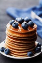 Stack of baked american pancakes or fritters with blueberries and honey syrup on rustic dark table. Delicious breakfast. Royalty Free Stock Photo