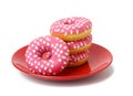 Stack of baked donuts with pink frosting on a red round plate, food isolated on blue background