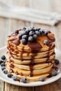 Stack of baked pancakes or fritters with chocolate sauce and frozen blueberries in a white plate Royalty Free Stock Photo